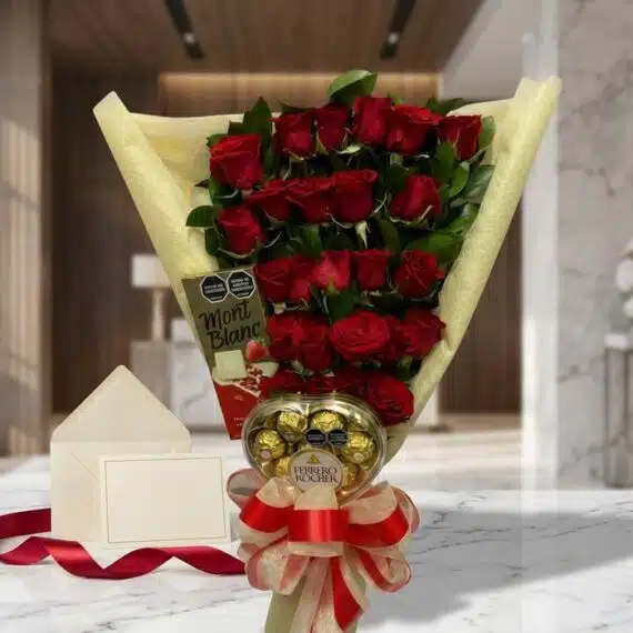 Arreglo floral de rosas rojas con chocolates Ferrero Rocher y tarjeta de regalo en un elegante entorno de mármol.