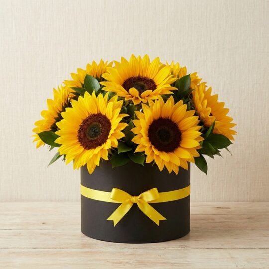Arreglo floral de girasoles MARISA en caja negra con lazo amarillo, ideal para ecommerce de floristería, con fondo elegante e