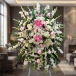 Pedestal fúnebre 'Pasión' con lirios rosados, rosas pálidas y gladiolos blancos, en sala de velación premium con luz natural.
